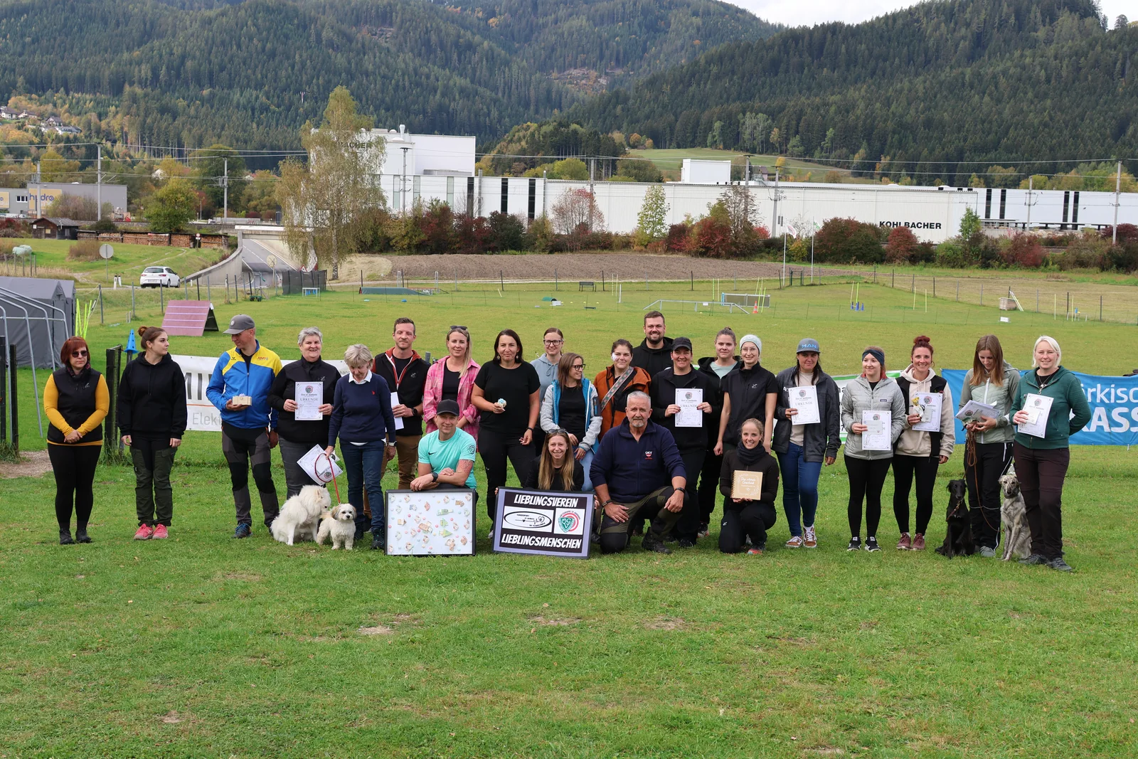 Großes Gruppenfoto mit Menschen und Hunden auf dem Vereinsgelände